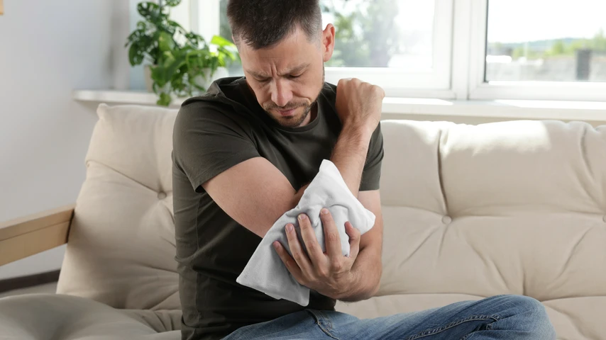 Man using heat pack on elbow